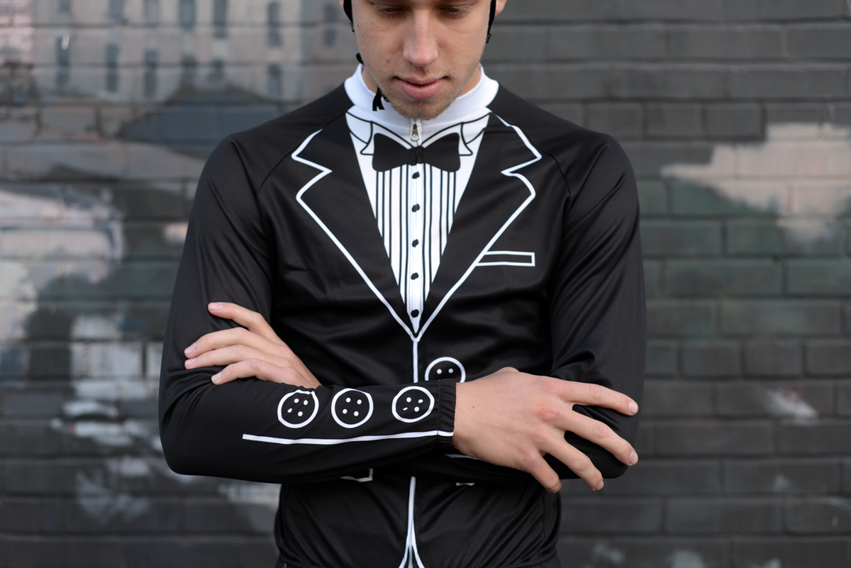 Rider in the Corbah Tuxedo long sleeve jersey, arms crossed, in front of a brick wall
