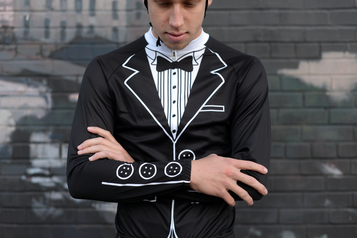 Rider in the Corbah Tuxedo long sleeve jersey, arms crossed, in front of a brick wall