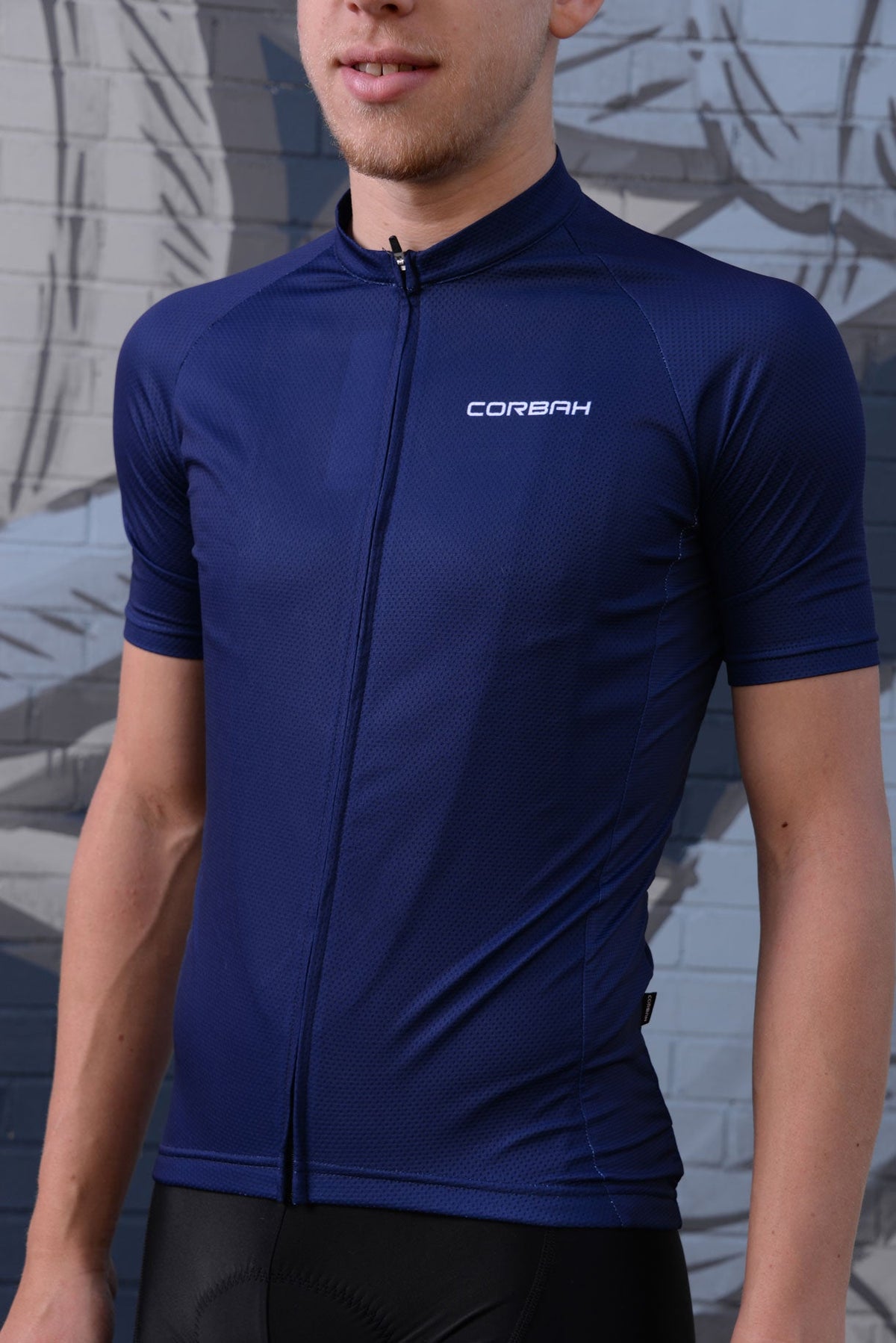 Rider in the men's Classics Deep Blue jersey: plain navy with white Corbah chest logo