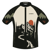 Front artwork of the Corbah TOUGH After the Climb jersey: bone chest with Corbah wordmark, rust sun over ink mountains and a bone switchback road split by a black zip strip, charcoal topo sleeves with olive pine ridges and two rust cuff bars.