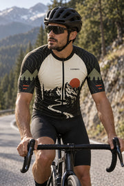 Rider in the Corbah TOUGH jersey on a mountain road lined with pines, front three-quarter view showing the rust sun, peaks and switchback road artwork (AI visualization; bib shorts not included).